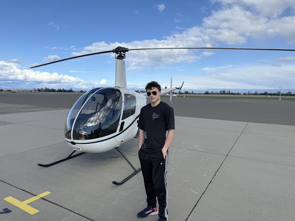 Ben standing next to a helicopter on an airfield